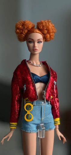 a barbie doll with red hair and blue shorts is wearing a red sequin jacket