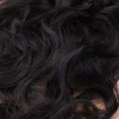 the top part of a woman's head with wavy hair on it, close up