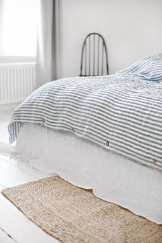 an unmade bed with blue and white linens