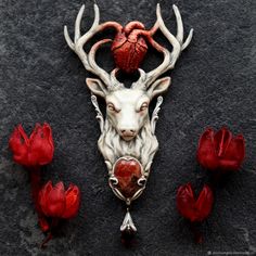 a white deer head with red roses around it