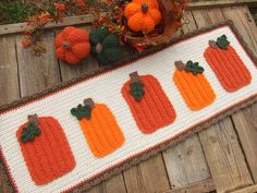 a crocheted table runner with pumpkins on it