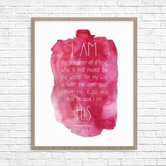 a pink watercolor print with the words i am and his on it, against a white brick wall