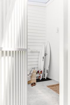 two surfboards are propped up against the wall next to each other in a white room