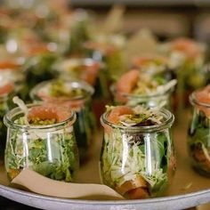 several jars filled with food sitting on top of a metal tray covered in lettuce