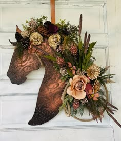 a horse head decorated with flowers and leaves on the front door to a house or business