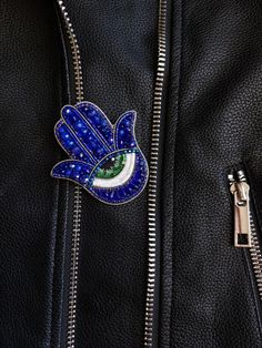 a close up of a leather jacket with a bird pin on it