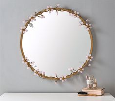 a mirror that is on the wall above a desk with a brush and toothbrush