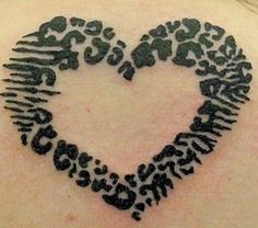 a heart made out of letters on the back of a woman's upper arm