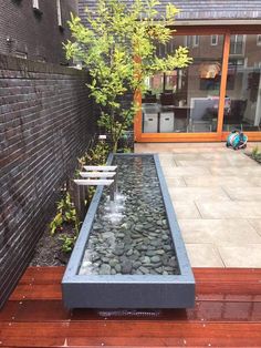 a small water feature in the middle of a wooden deck