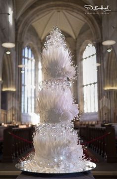 a tall white cake sitting on top of a table