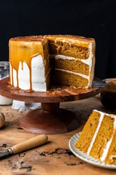 a cake sitting on top of a wooden table covered in frosting next to a knife