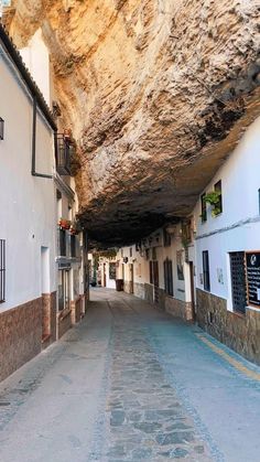 an empty street with buildings and large rocks