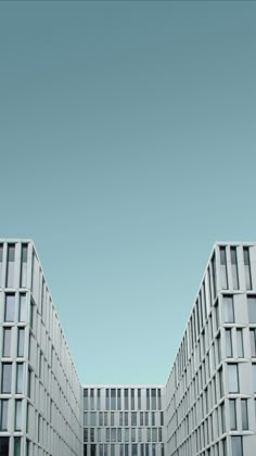 two large white buildings with windows on each side and one smaller building in the middle