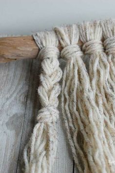 a close up of some yarn on a wooden floor with a piece of wood in the background