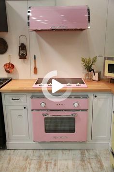 a pink stove top oven sitting inside of a kitchen next to a wall mounted oven