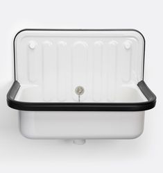 an empty white and black sink with the lid down on it's side, against a white background