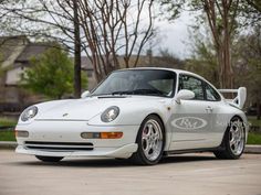 a white sports car parked in a parking lot