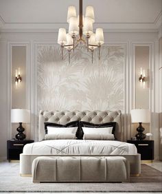 a large bed sitting under a chandelier next to two lamps on either side of it