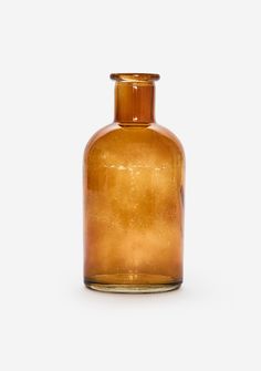 a brown glass bottle sitting on top of a white table