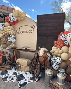 a horse is standing next to some balloons and other items on display in front of a building