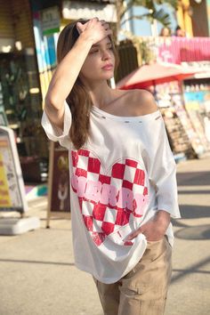 Distressed, garment washed graphic t-shirt Vintage-style, checker Valentine heart graphic with "Cherry" text. Torn and distressed detailing at neckline, cuffs, and hem. Round neckline. Short sleeves. Drop shoulder. Oversized fit. 100% Cotton. Imported top designed and printed in LA. Model wears size S. Retro Summer Tops With Heart Graphic, Trendy White Distressed Tops, Mini Dress Formal, Valentine Heart, Oversized Fits, Round Neckline, One Piece Swimsuit, Sweater Cardigan, Cherry