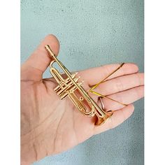 a person holding a brass trumpet pin in their hand