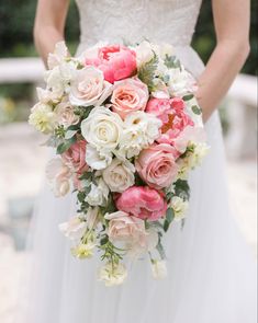 a bridal holding a bouquet of pink and white flowers