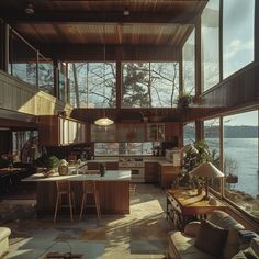 an open kitchen and living room area with large windows overlooking the water's edge