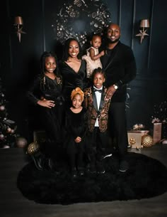 a family posing for a photo in front of a christmas tree