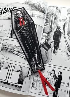 an open book with black and white illustrations on it, including a red ribbon tied to the pages