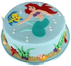 there is a blue cake with an image of a mermaid on it