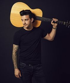 a man holding an acoustic guitar over his head