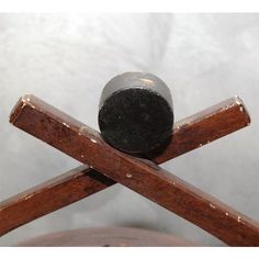 an old wooden cross with a metal ball on it's end and some wood sticks sticking out of the top