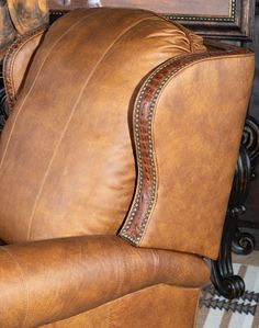 a brown leather recliner sitting on top of a rug