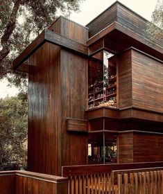 a tall wooden building sitting next to a lush green forest