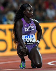 a woman kneeling down on top of a track