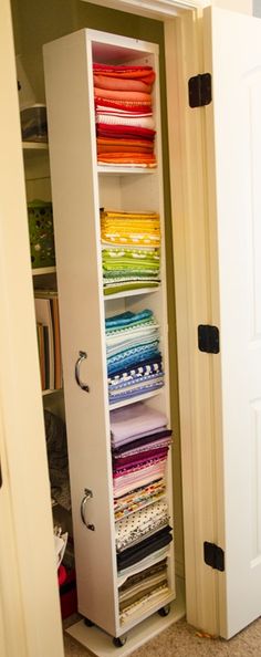 an open closet filled with lots of different colored fabrics and quilting material in it