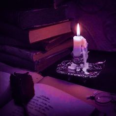 a lit candle sitting on top of an open book