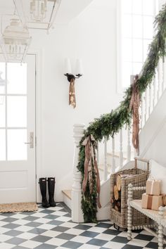 a staircase decorated for christmas with garland and bows