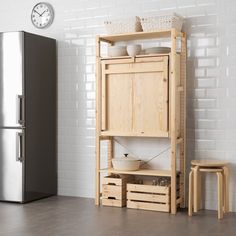 a wooden cabinet sitting next to a refrigerator freezer in a room with white brick walls