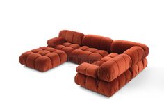 an orange couch sitting on top of a white floor next to a chair and ottoman