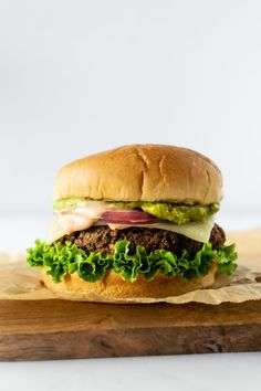 a large hamburger with lettuce and meat on it