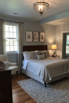 a bedroom with a large bed and two windows