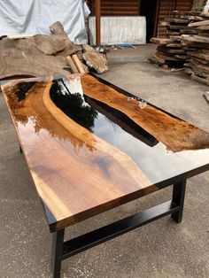 a table made out of wood and metal with a reflection in the water on it