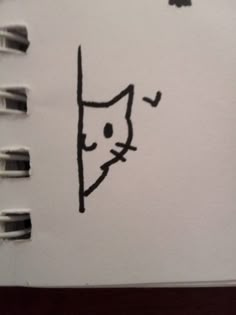 a notepad with a drawing of a cat peeking out of it's corner