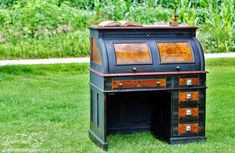 an old fashioned desk is sitting in the grass