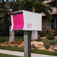 a pink and white mailbox in front of a house