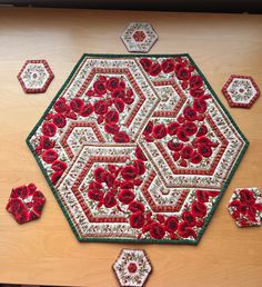 a table with red flowers and hexagons on it