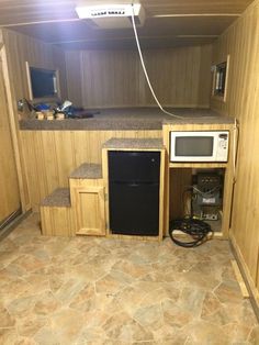 a kitchen area with a microwave, refrigerator and sink in it's corner next to a counter