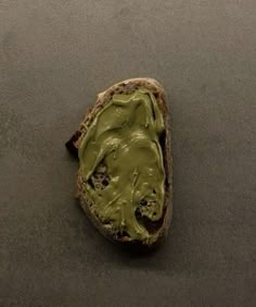 a piece of bread with green spread on it